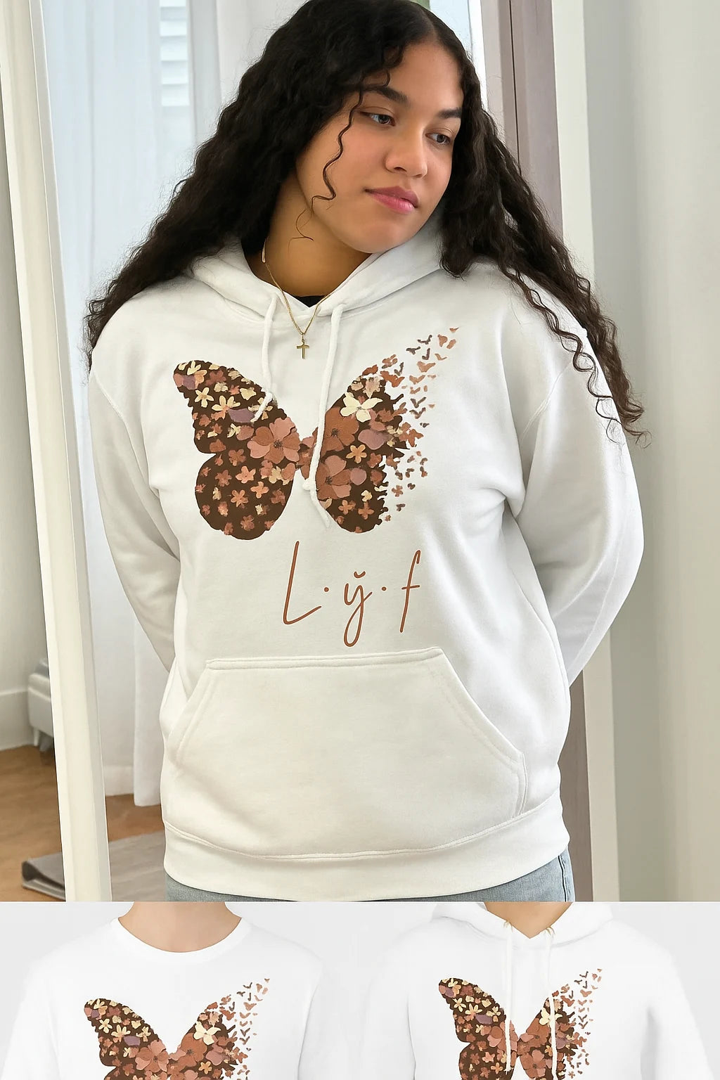 Person wearing a white hoodie with a butterfly design and &